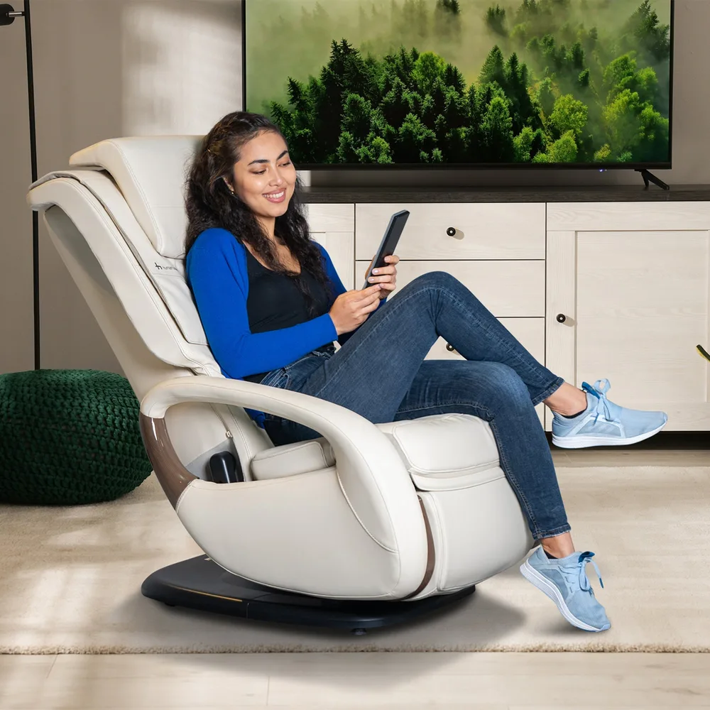 Human Touch WholeBody 8.0 recliner in cream with a woman reclining in a living room